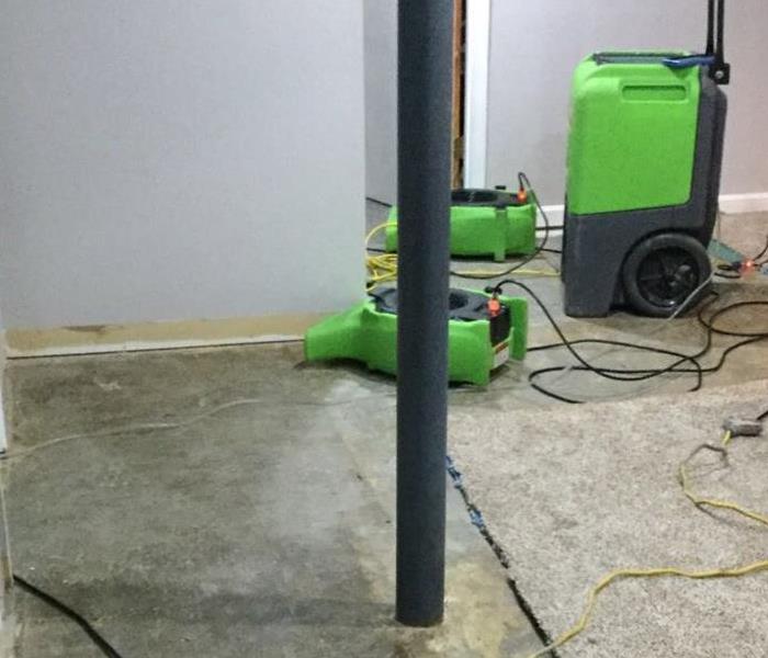 Carpet and padding removed with SERVPRO equipment placed throughout the area in a finished basement.