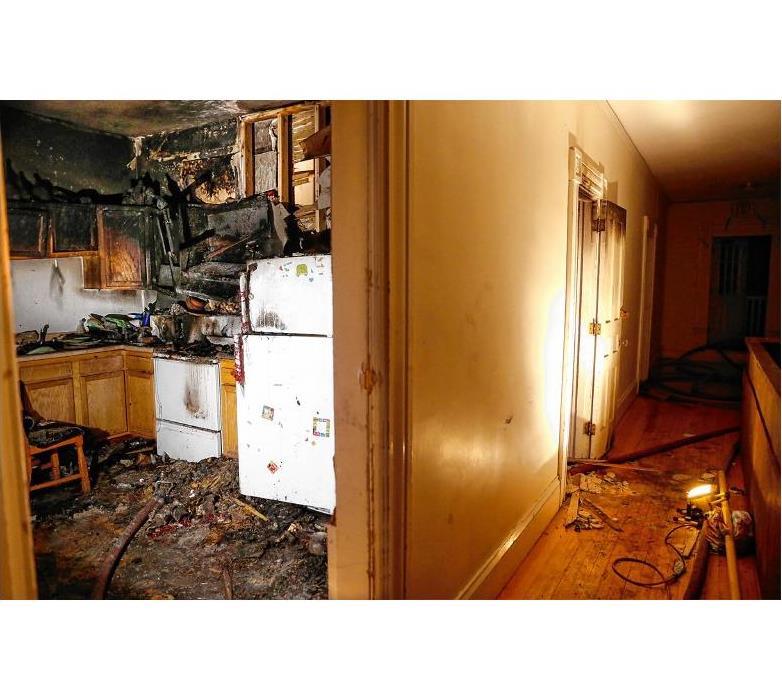 Kitchen fire. Image shows fire damage cabinets and flooring. Smoke damage to entire home.