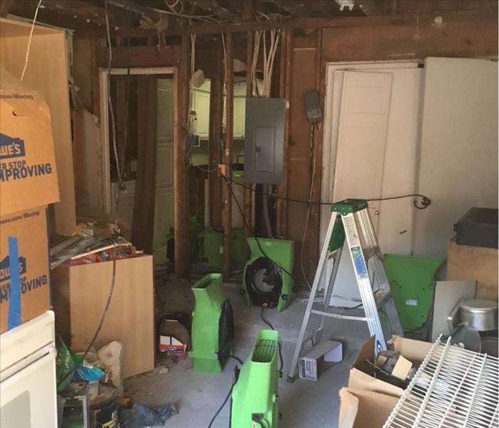 In this photo the drywall & insulation has been removed from the ceiling and SERVPRO air movers are placed in position. 