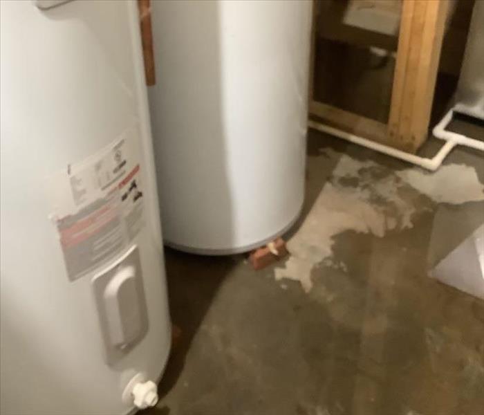 two water heaters, water surrounding concrete floor