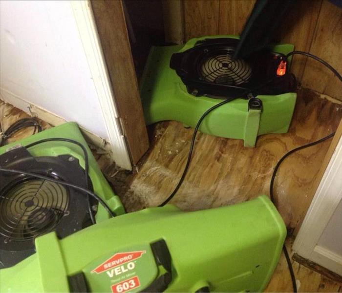 Three green SERVPRO brand Air Movers drying out a closet and wood flooring. 