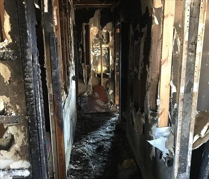 Hallway destroyed by fire, soot and debris covering the house from top to bottom. 